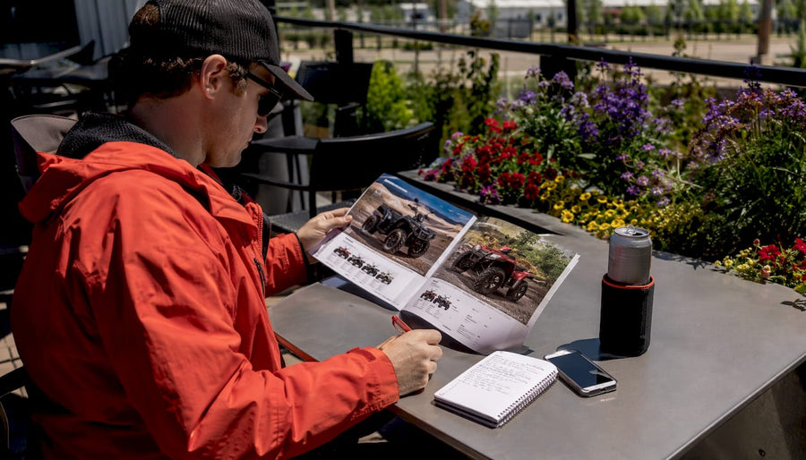 Canadian buyer comparing CFMOTO and Polaris brochures