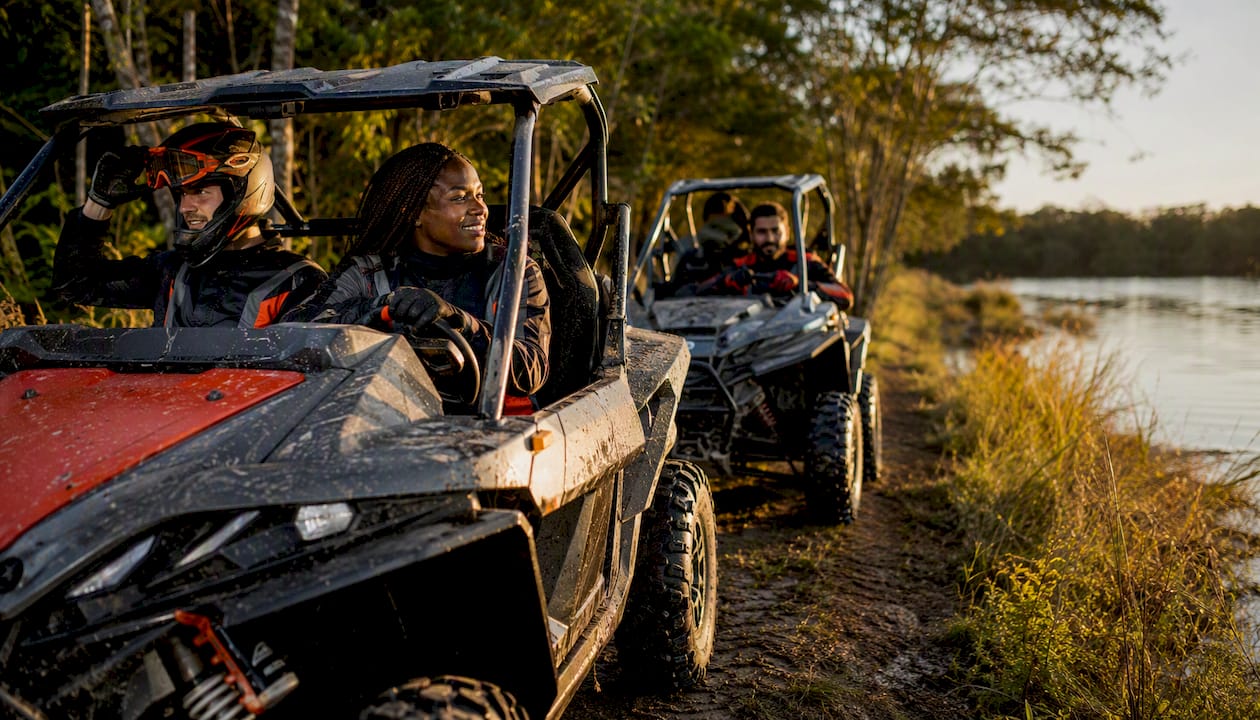 Group riding UTVs on forest trail