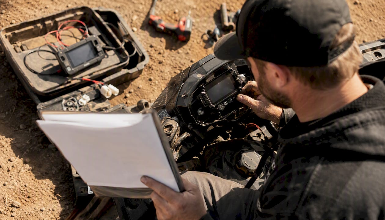 Technician checking ATV dash with tools