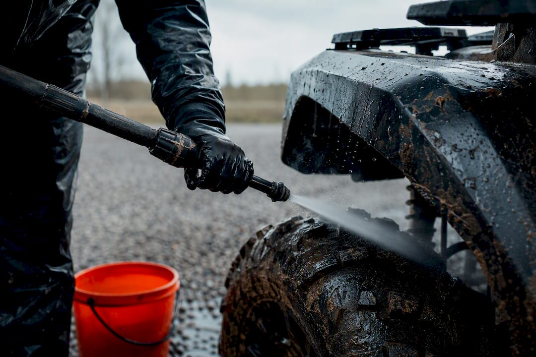 Rider safely rinsing ATV after muddy ride
