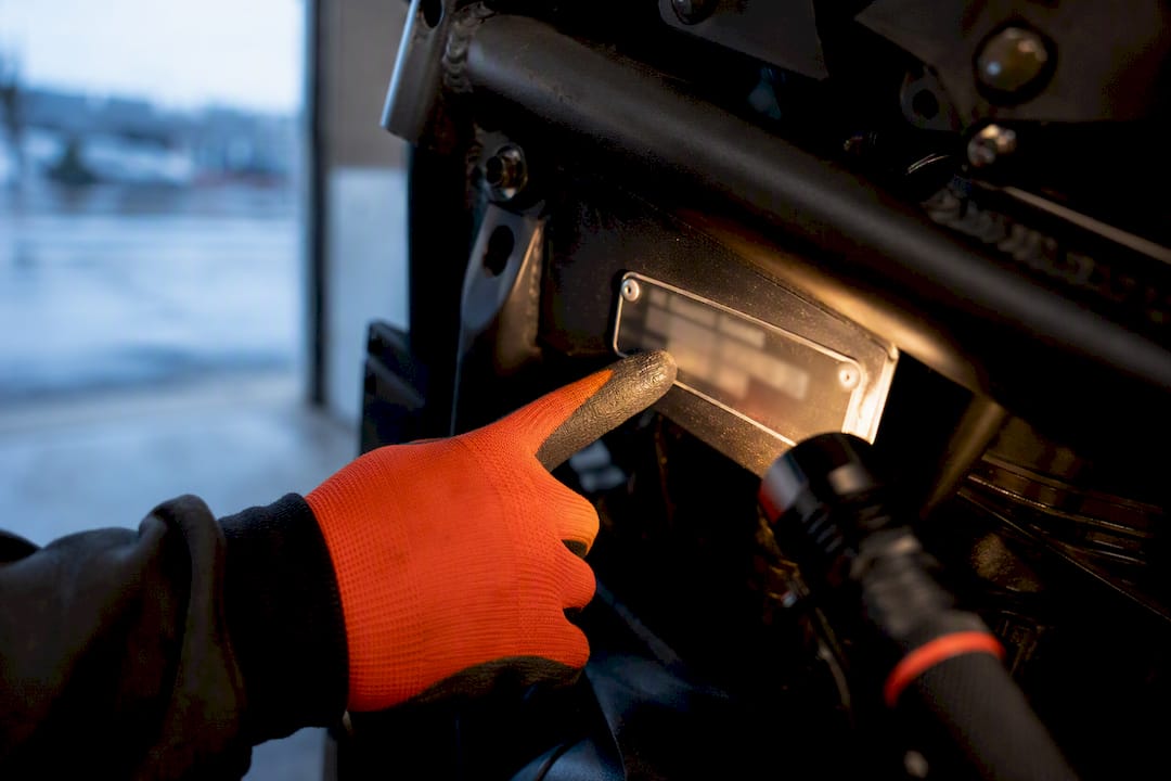 Technician inspecting a vehicle identification plate