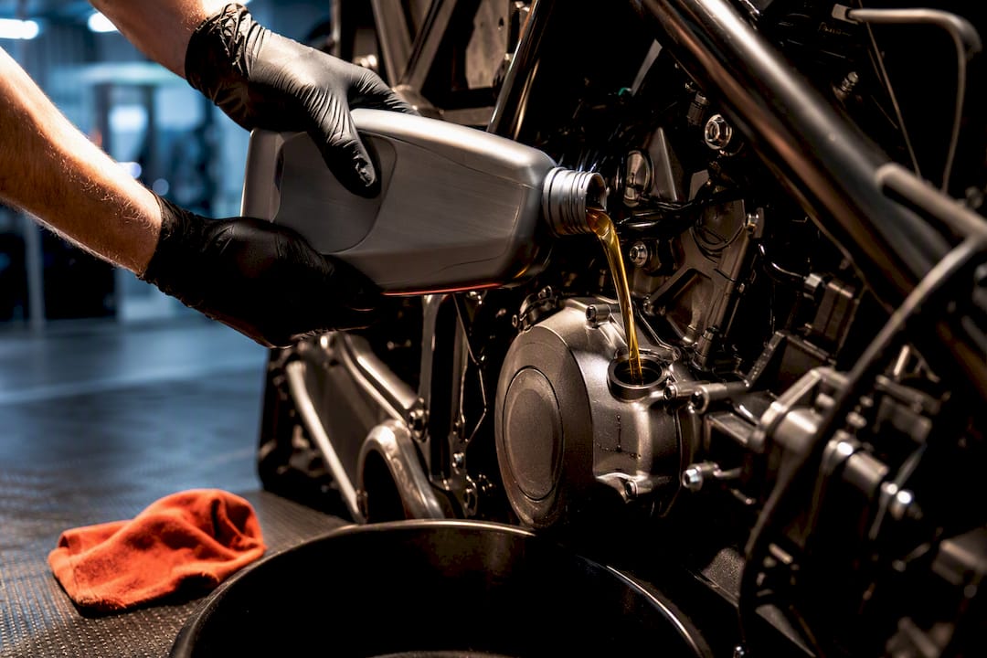 Technician adding oil to an off-road engine