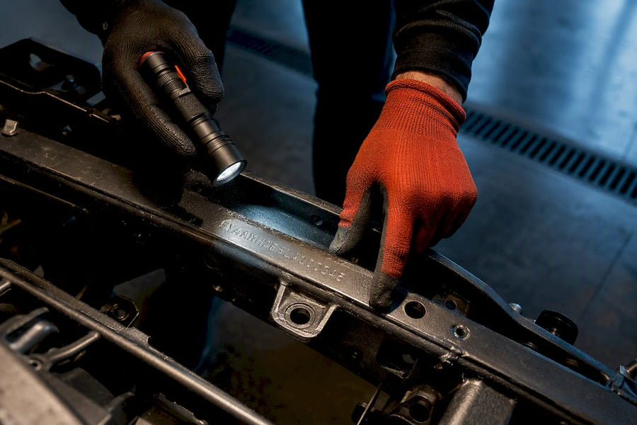 Technician inspecting stamped ATV frame VIN