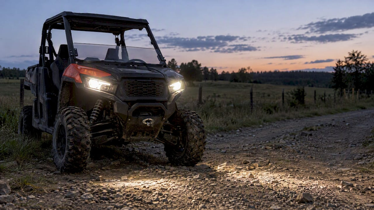 UTV headlights illuminating a farm track