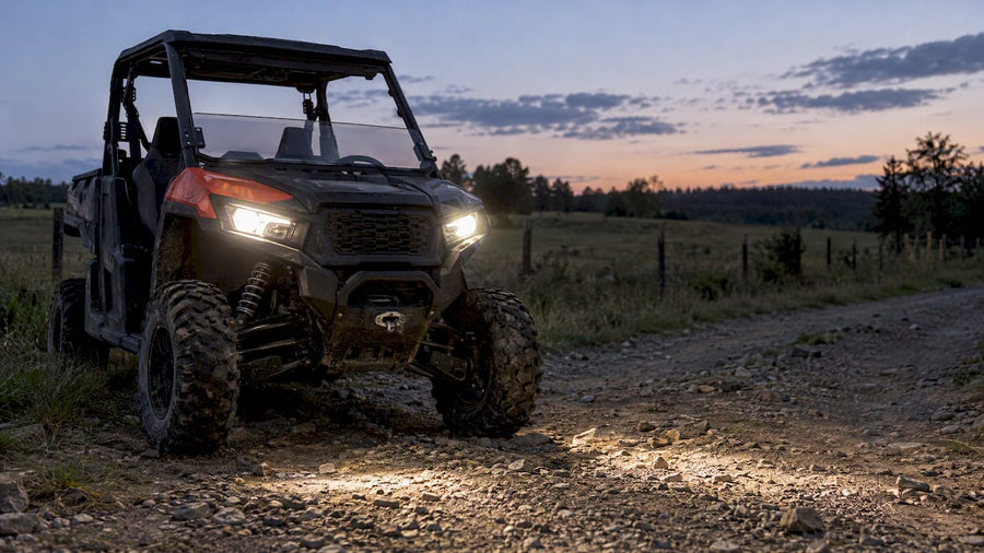UTV headlights illuminating a farm track
