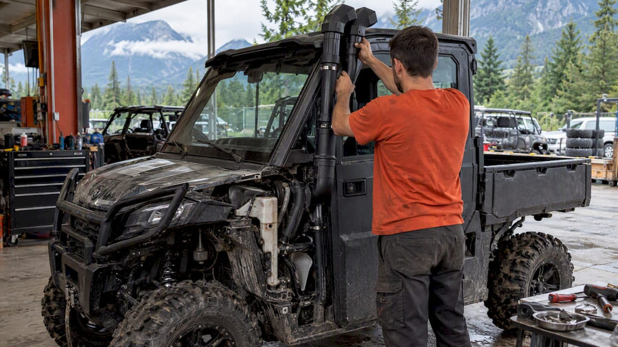 Technician fitting snorkel piping to CFMOTO UFORCE